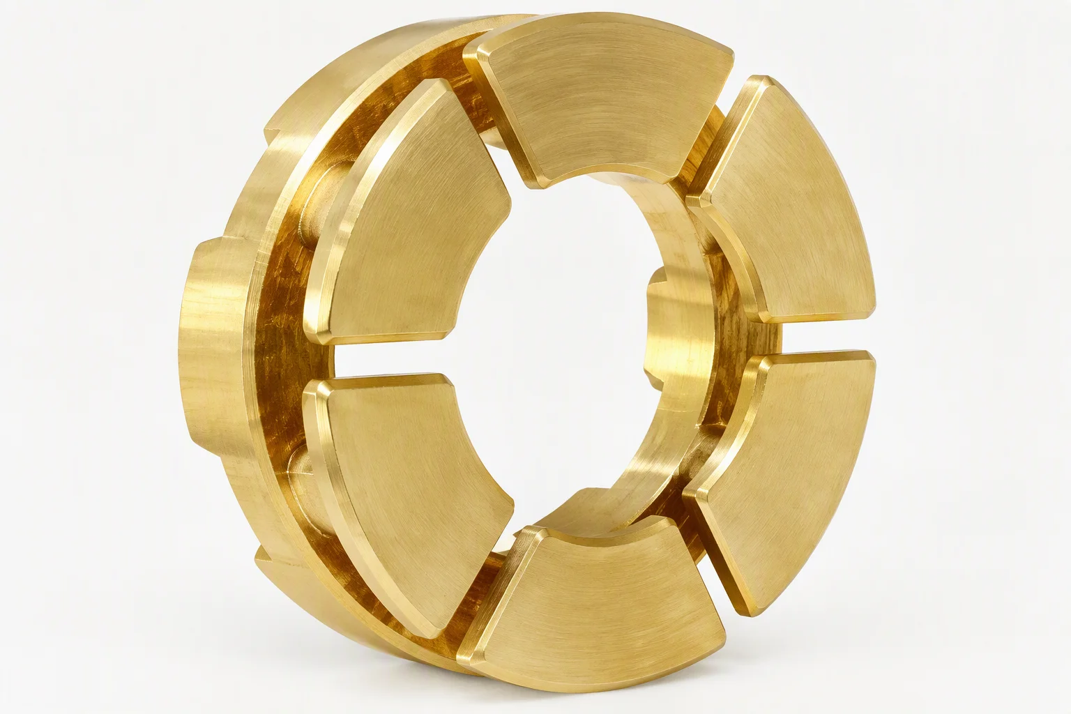 A brass thrust bearing pad set: sector-shaped pads with machined grooves arranged in a ring on a brushed gold ground