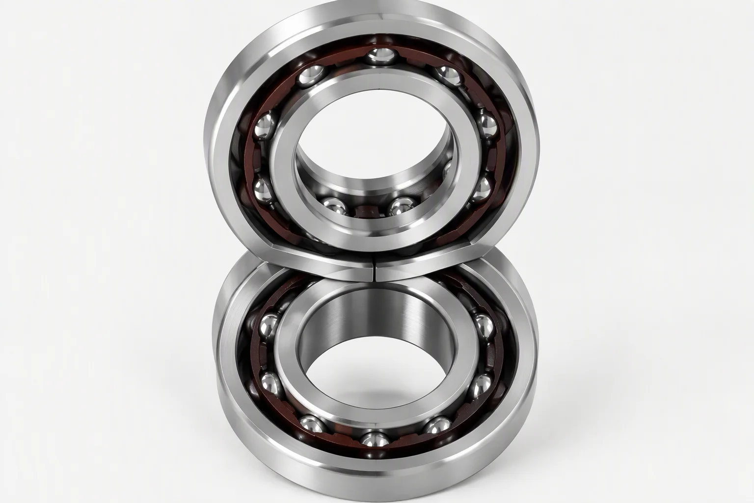 Two angular contact ball bearings stacked one above the other, each with a dark phenolic cage and a ring of steel balls