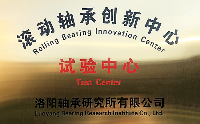 A dark bronze plaque with engraved lettering on an amber lit background, naming a rolling bearing innovation centre and test centre